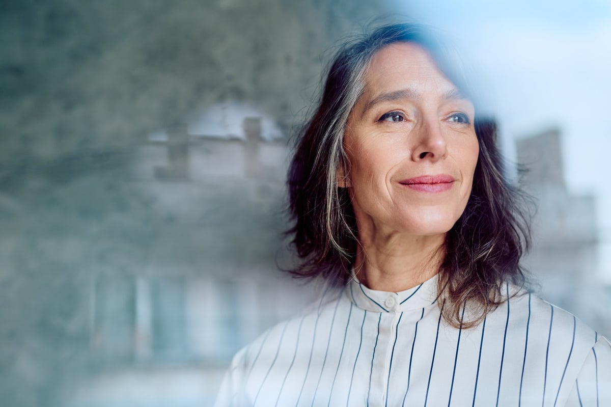 Confident woman smiling, representing natural confidence and facial balance